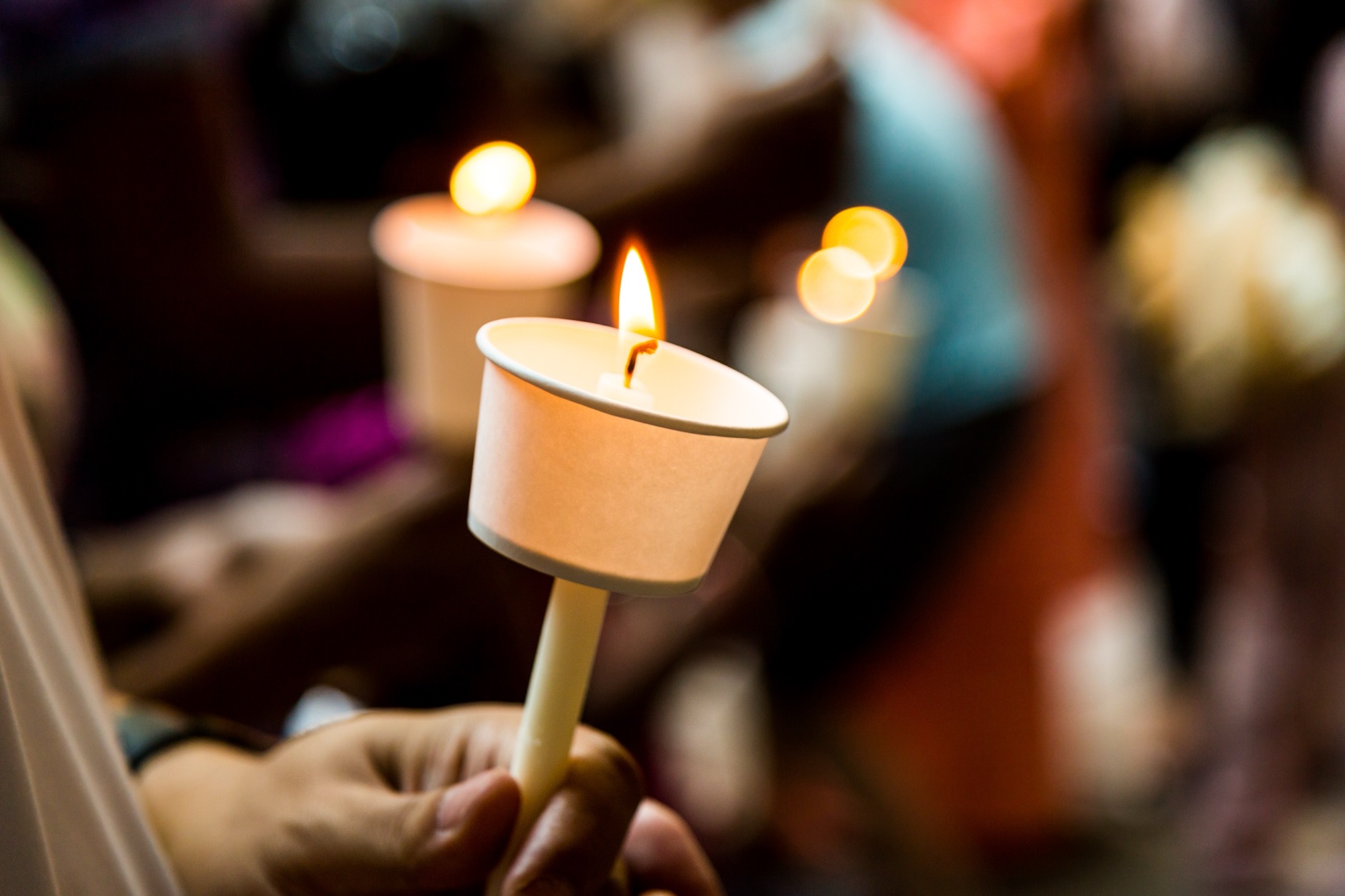 Candles held at a vigil, representing remembrance and community